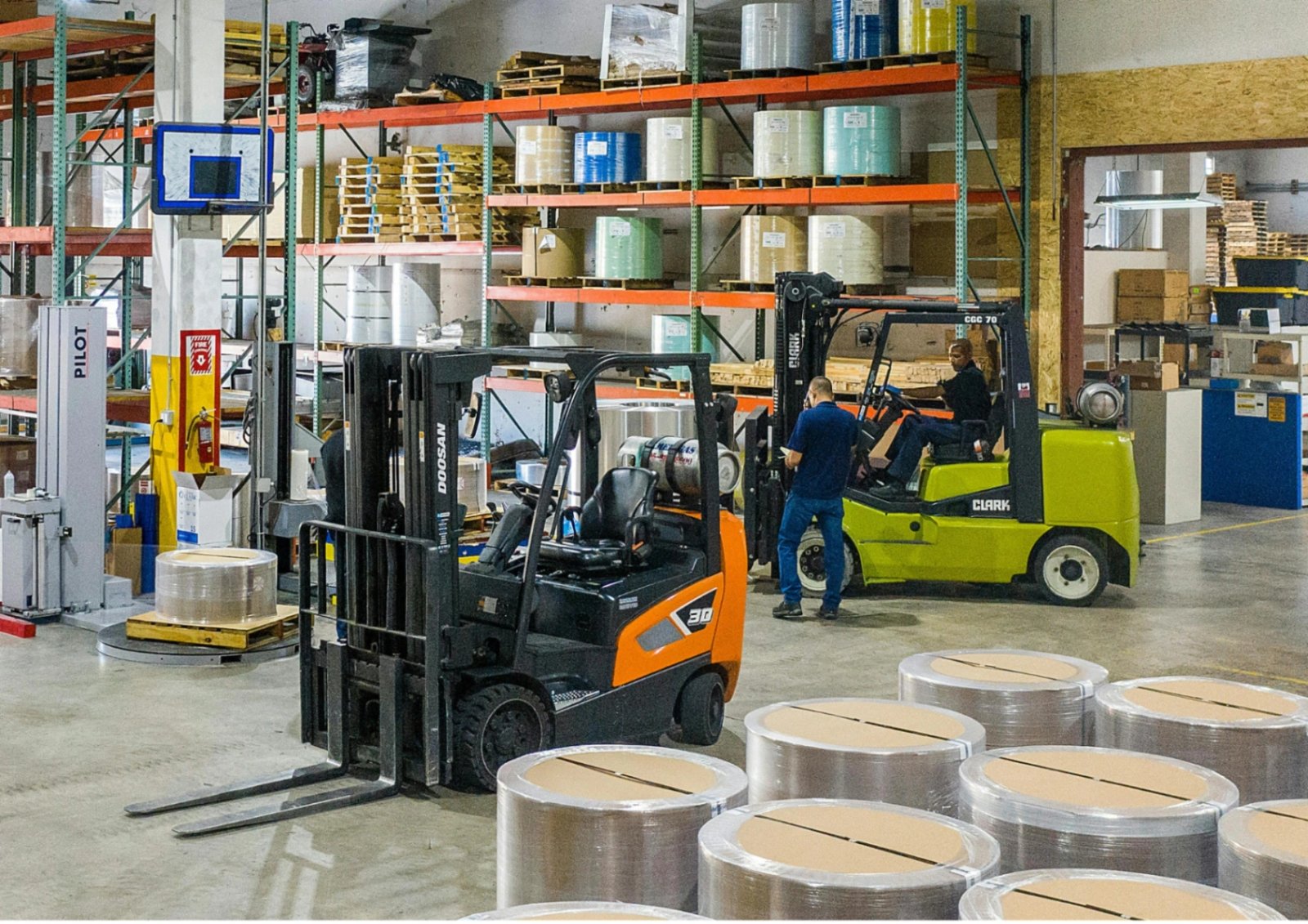 A forklift loading pallets in a busy cross docking warehouse